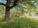 Well maintained brick home with green grass and mature trees providing shade at 6335 Linden Dr, Indianapolis, IN 46227