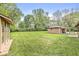 Large, grassy backyard with detached garage and small structure, ideal for outdoor activities and storage at 6401 N Oakland Ave, Indianapolis, IN 46220