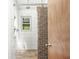 This bathroom boasts a tiled walk-in shower with a modern showerhead and wood look flooring at 6401 N Oakland Ave, Indianapolis, IN 46220
