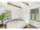 Minimalist bedroom featuring hardwood floors, a skylight, and two large windows for natural light at 6401 N Oakland Ave, Indianapolis, IN 46220