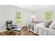 Relaxing bedroom featuring hardwood floors, ample light from windows, and a comfortable chair and bed at 6401 N Oakland Ave, Indianapolis, IN 46220