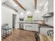 A kitchen featuring stainless steel appliances, hardwood floors, white cabinets and wooden beams at 6401 N Oakland Ave, Indianapolis, IN 46220