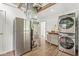 A laundry room featuring stacked washer and dryer, refrigerator and hardwood floors at 6401 N Oakland Ave, Indianapolis, IN 46220