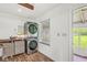A laundry room featuring stacked washer and dryer, wooden beams and hardwood floors at 6401 N Oakland Ave, Indianapolis, IN 46220