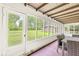 A screened in porch featuring hardwood floors, a table and chairs and view of the back yard at 6401 N Oakland Ave, Indianapolis, IN 46220