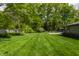 Large backyard with lush green grass and mature trees at 7770 N Pennsylvania St, Indianapolis, IN 46240