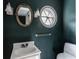 Stylish powder room with dark walls, round window, and unique mirror at 7770 N Pennsylvania St, Indianapolis, IN 46240
