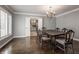 Formal dining room featuring hardwood floors, a chandelier, and an adjacent kitchen area at 7770 N Pennsylvania St, Indianapolis, IN 46240