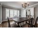 Sunlit dining room with a wooden table, floral chairs, and shuttered windows at 7770 N Pennsylvania St, Indianapolis, IN 46240