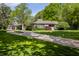 Charming single-story home with lush landscaping and a long driveway on a sunny day at 7770 N Pennsylvania St, Indianapolis, IN 46240