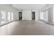 Open living room with tile floors, double french doors, and windows with views at 7770 N Pennsylvania St, Indianapolis, IN 46240