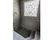 Luxurious tiled shower with stained glass window and a built-in bench at 7770 N Pennsylvania St, Indianapolis, IN 46240