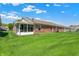 Beautiful backyard with well-kept lawn and the rear home exterior featuring a screened in porch at 8145 Bentley Farms Dr, Indianapolis, IN 46259