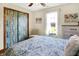 Bright bedroom features a patterned comforter, wood-look floors, and closet with sliding doors at 8145 Bentley Farms Dr, Indianapolis, IN 46259