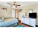 Well-lit bedroom features a ceiling fan, white dresser, and doorway to another room at 8145 Bentley Farms Dr, Indianapolis, IN 46259