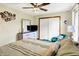 Bright bedroom features a ceiling fan, dresser with TV, and comfortable accent chair at 8145 Bentley Farms Dr, Indianapolis, IN 46259