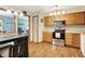 Bright kitchen featuring stainless steel appliances and light wood cabinets, seamlessly connected to dining area at 8145 Bentley Farms Dr, Indianapolis, IN 46259