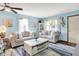 Bright living room featuring soft blue walls, neutral furniture, and ample natural light at 8145 Bentley Farms Dr, Indianapolis, IN 46259