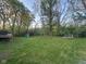 A lush, green backyard features mature trees, a playset, and a serene hammock at 8507 Promontory Rd, Indianapolis, IN 46236