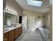 Bright bathroom with dual sinks, a soaking tub, and a skylight offering natural light at 8507 Promontory Rd, Indianapolis, IN 46236