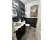 Stylish half bathroom with decorative mirror, vanity, and dark wainscoting at 8507 Promontory Rd, Indianapolis, IN 46236