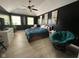Spacious bedroom with dark accent wall, ceiling fan, and natural light from three large windows at 8507 Promontory Rd, Indianapolis, IN 46236