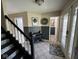 Inviting foyer with tile flooring, decorative accents, and staircase with black railing at 8507 Promontory Rd, Indianapolis, IN 46236