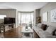 Bright living room featuring hardwood floors, gray sofa, and a bay window with natural light at 863 N Park Trail Dr, Carmel, IN 46032