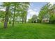 Spacious grassy yard surrounded by mature trees, offering a serene outdoor environment at 863 N Park Trail Dr, Carmel, IN 46032