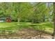 Lush backyard featuring mature trees, a shed, and ample green space at 8636 Rockville Rd, Indianapolis, IN 46234