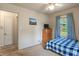 Cozy bedroom features a blue-checkered bed, a wooden dresser, and natural light at 8636 Rockville Rd, Indianapolis, IN 46234