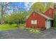 Side view of a red home with a shed and landscaped yard in a green setting at 8636 Rockville Rd, Indianapolis, IN 46234