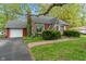 Charming red brick home featuring a well-manicured lawn and a detached garage at 8636 Rockville Rd, Indianapolis, IN 46234