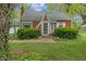 View of the red brick home, showcasing the manicured lawn and mature trees at 8636 Rockville Rd, Indianapolis, IN 46234