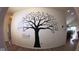 Charming wall decor showcasing a large Gathering tree mural on a white wall in the home's interior at 934 Steel Horse Dr, Westfield, IN 46074