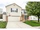Charming two-story home featuring an attached two car garage, landscaped yard, and a brick-accented entryway at 941 Pine Ridge Way, Brownsburg, IN 46112