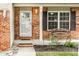 Inviting front porch with brick accents, a decorative bench, and well-maintained landscaping at 941 Pine Ridge Way, Brownsburg, IN 46112