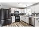Well-lit kitchen featuring stainless steel appliances, modern white cabinets, and stylish countertops at 941 Pine Ridge Way, Brownsburg, IN 46112