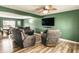 Cozy living room with a ceiling fan, a large TV, and comfortable reclining sofas at 941 Pine Ridge Way, Brownsburg, IN 46112
