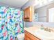 Charming bathroom featuring a colorful mermaid shower curtain, vanity, and wooden cabinet at 941 W Barouche, Pendleton, IN 46064