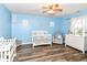 Comfortable Bedroom with a crib, rocking chair, white dresser, wood-look flooring, and natural light at 941 W Barouche, Pendleton, IN 46064
