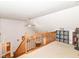 Bright loft area with carpet, ceiling fan, wooden railing and view of the staircase and small storage area at 941 W Barouche, Pendleton, IN 46064