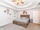Comfortable primary bedroom with a tray ceiling, a rustic wood frame bed and bright windows at 941 W Barouche, Pendleton, IN 46064