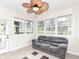 Bright sunroom with many windows, tile floors, a comfortable couch, and a modern ceiling fan at 941 W Barouche, Pendleton, IN 46064