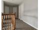 Hallway with neutral carpet and wooden banister and white doors at 9879 Brightwater Dr, Fishers, IN 46038