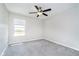 A view of the secondary bedroom with plush carpet, a ceiling fan, and a view of the neighborhood at 991 Terra Ln, Franklin, IN 46131