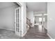 Inviting hallway with hardwood floors, complemented by a charming stairway and a glass-paneled office door at 991 Terra Ln, Franklin, IN 46131