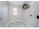 Functional laundry room with tile floor, window for natural light, and convenient shelf space for organization at 991 Terra Ln, Franklin, IN 46131