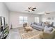Comfortable living room with gray sofa, ceiling fan, area rug, and abundant natural light from large window at 991 Terra Ln, Franklin, IN 46131