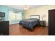 Cozy bedroom with hardwood floors, a queen-sized bed, and plenty of natural light at 9910 Suncoral Cir, Fishers, IN 46038